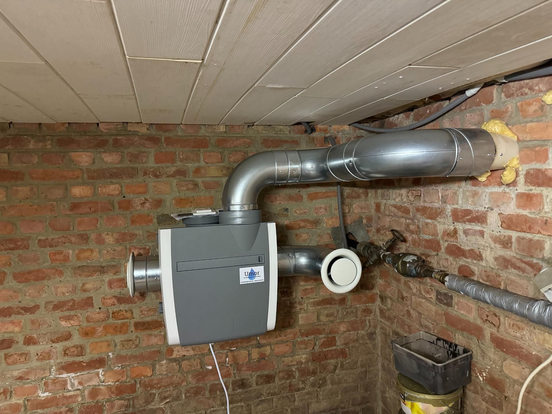 Ventilatie-unit aan een bakstenen muur, klaar voor onderhoud van het ventilatiesysteem